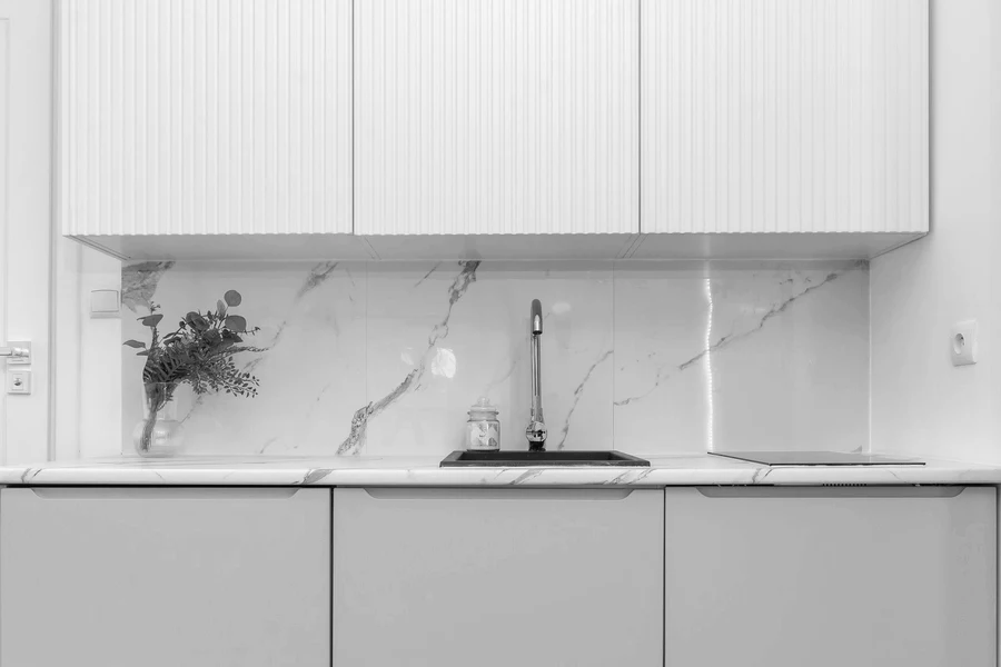 Handleless kitchen run with a marble backsplash